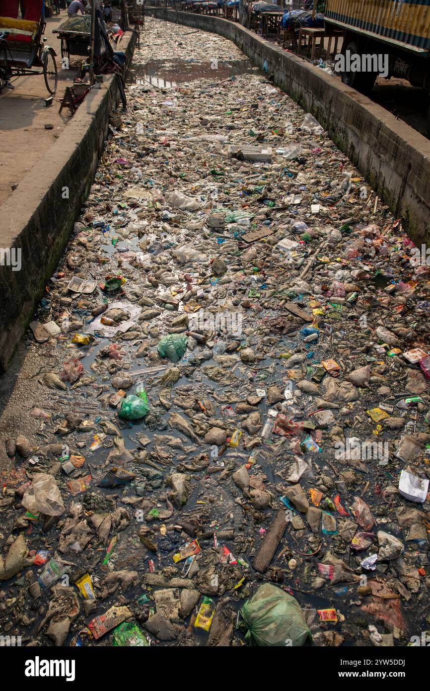 Des déchets plastiques de divers types recouvrent un canal à Dhaka, au Bangladesh, mettant en évidence un problème environnemental urgent. Banque D'Images