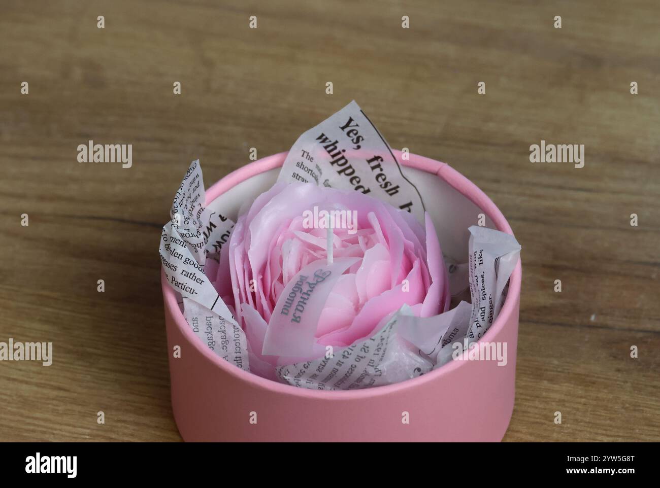 Une bougie en forme de fleur dans une mini boîte. Emballage cadeau. Banque D'Images