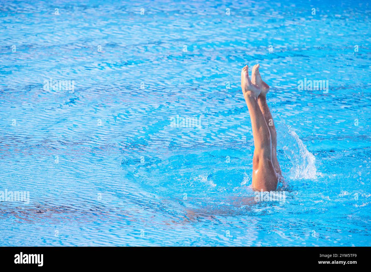 Femme nageuse artistique effectuant des mouvements de jambes chorégraphiés dans la piscine Banque D'Images