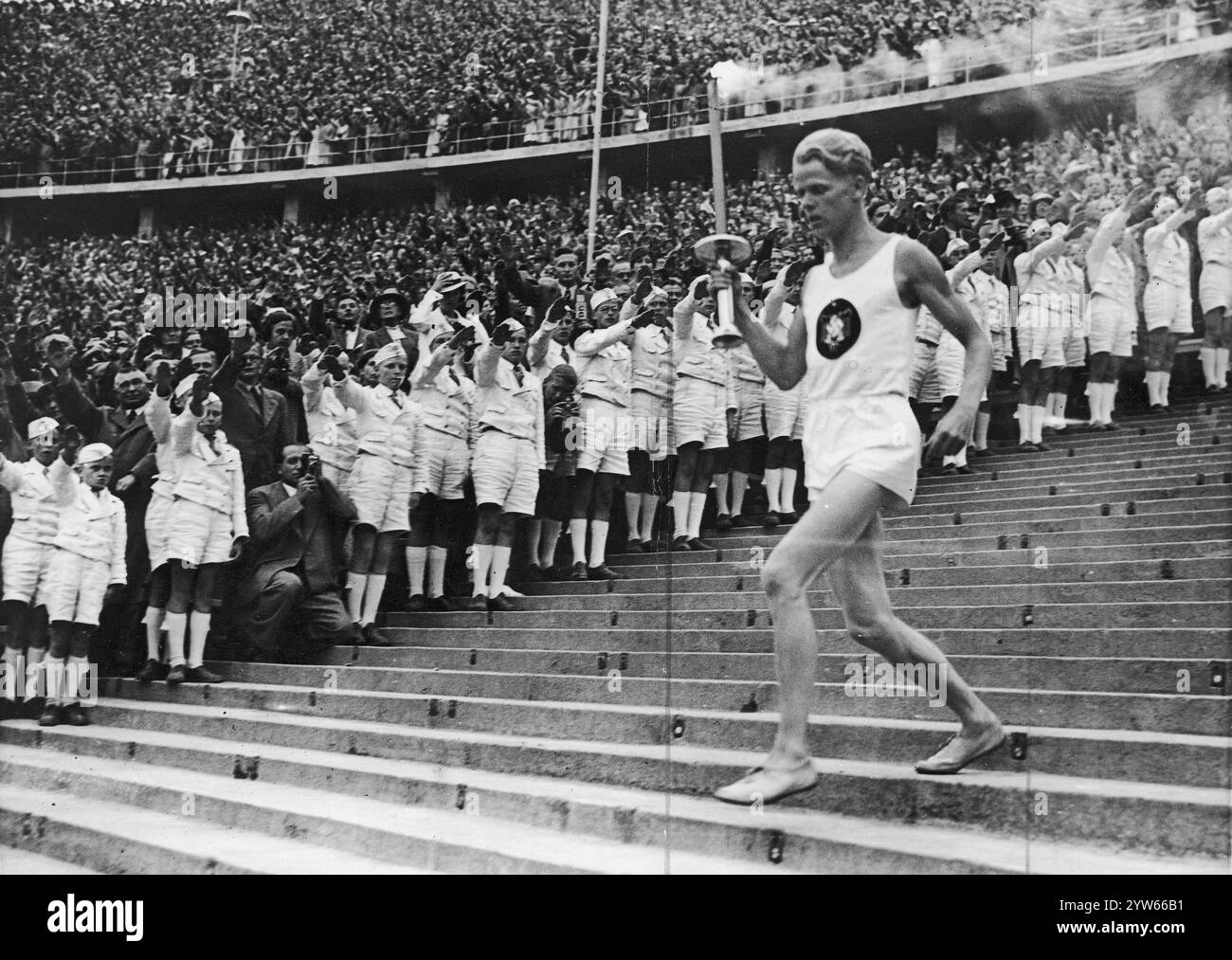 Le coureur allemand Erik Schilgen entre dans le stade avec une torche lors de la cérémonie d'ouverture des Jeux Olympiques de Berlin. Photographie d'archives des Jeux olympiques d'été de 1936 à Berlin Banque D'Images