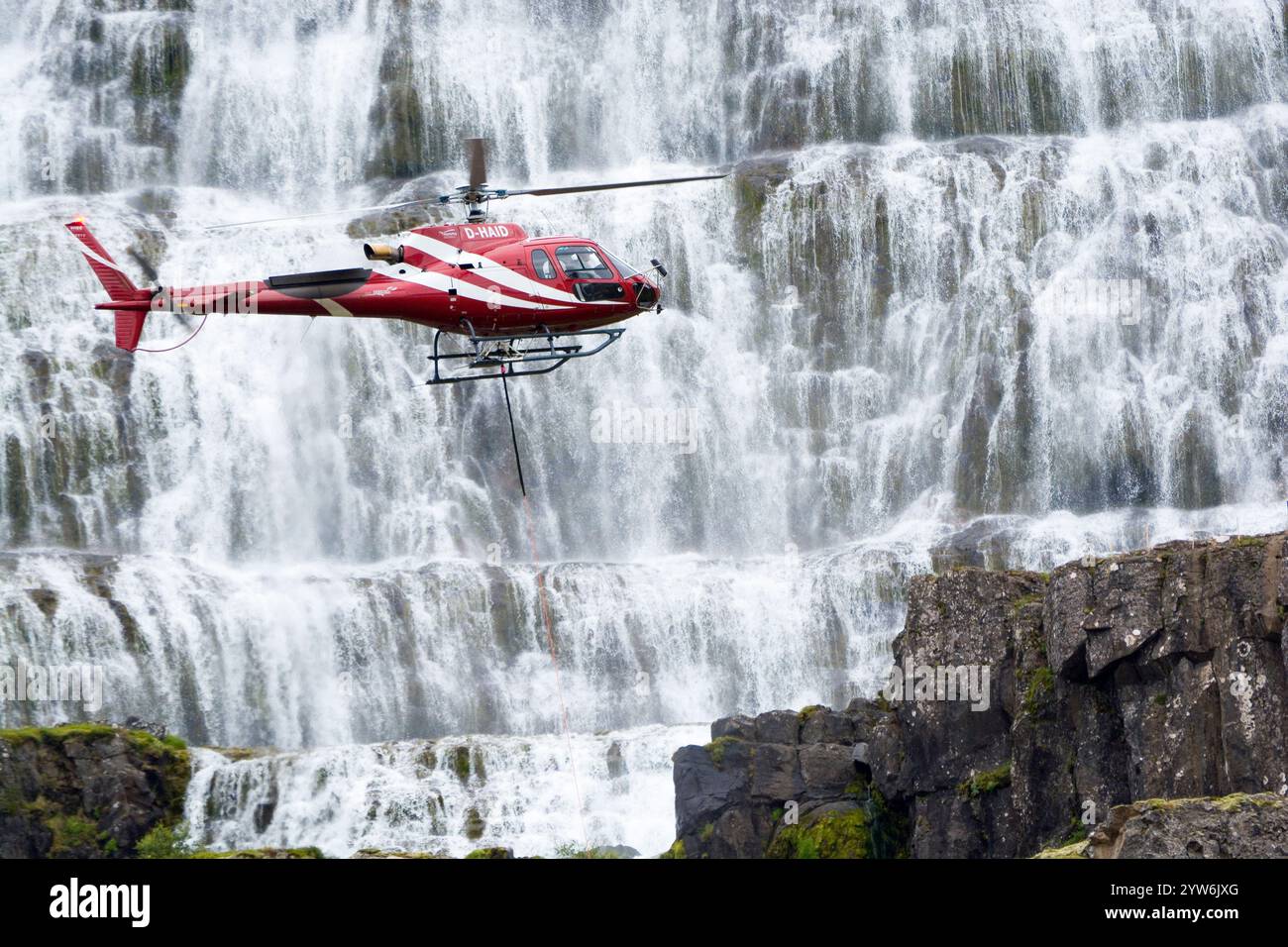 Hélicoptère Airbus H125 volant près d'une cascade de Dynjandi dans la région des Westfjords en Islande Banque D'Images