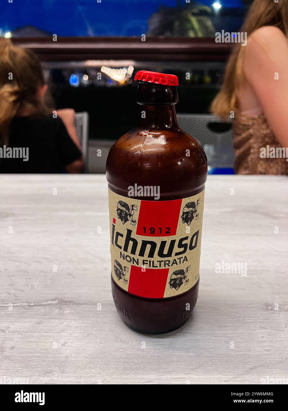 Porto Sant'Elpidio, Italie - 06 juillet 2022 : une image focalisée d'une bouteille de bière Ichnusa avec un bouchon rouge sur une table aux tons clairs, serrée contre un même flou Banque D'Images