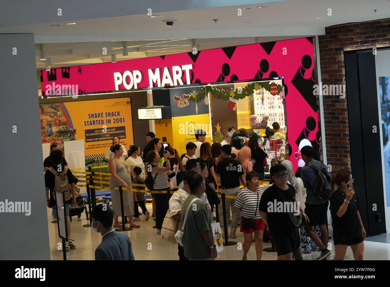 Bangkok, Thaïlande - 26 novembre 2024 : les gens marchent en ligne devant le magasin de jouets Pop Mart Banque D'Images