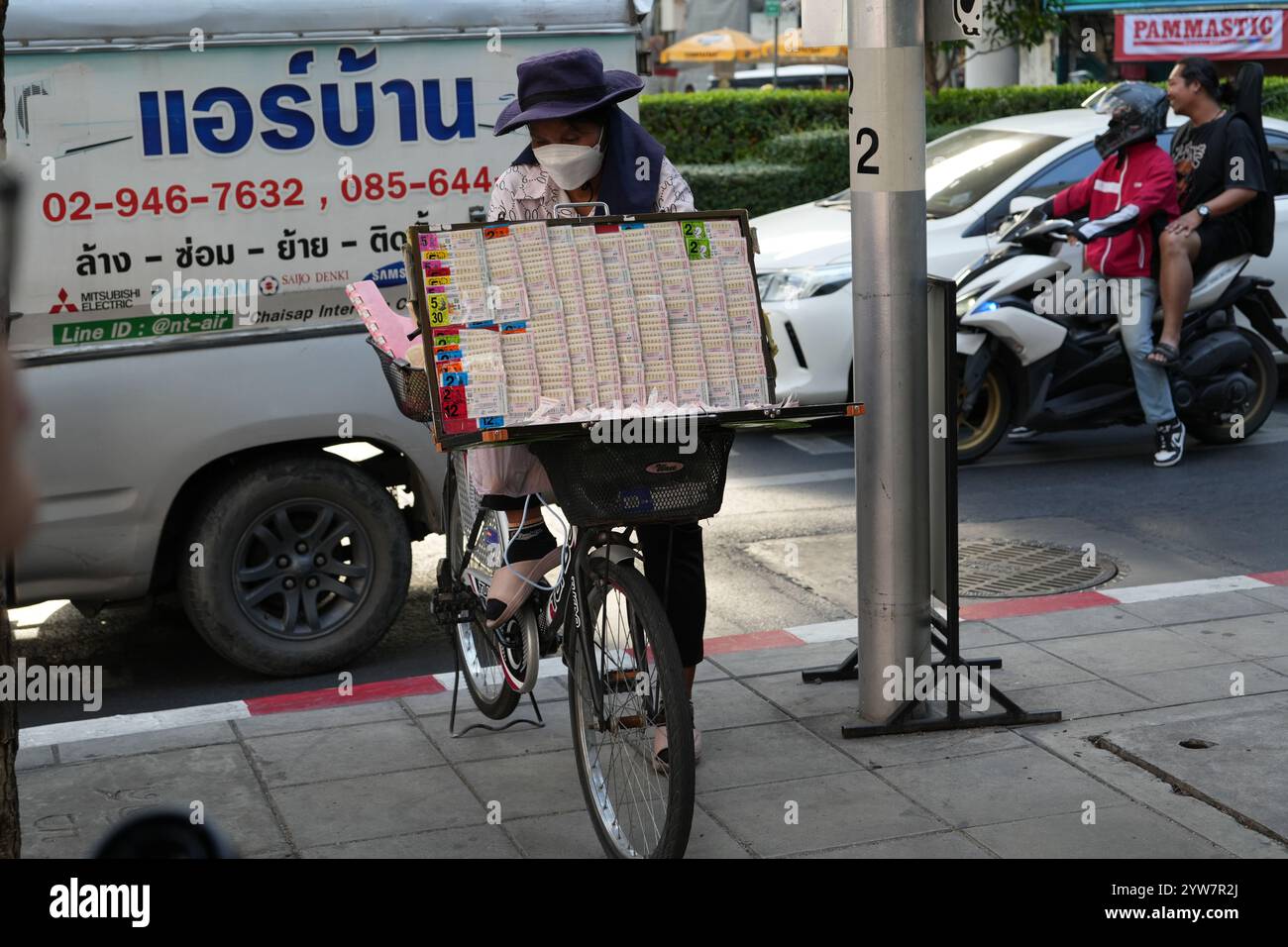 Bangkok, Thaïlande - 26 novembre 2024 : une dame vendant des billets de loterie de son vélo Banque D'Images