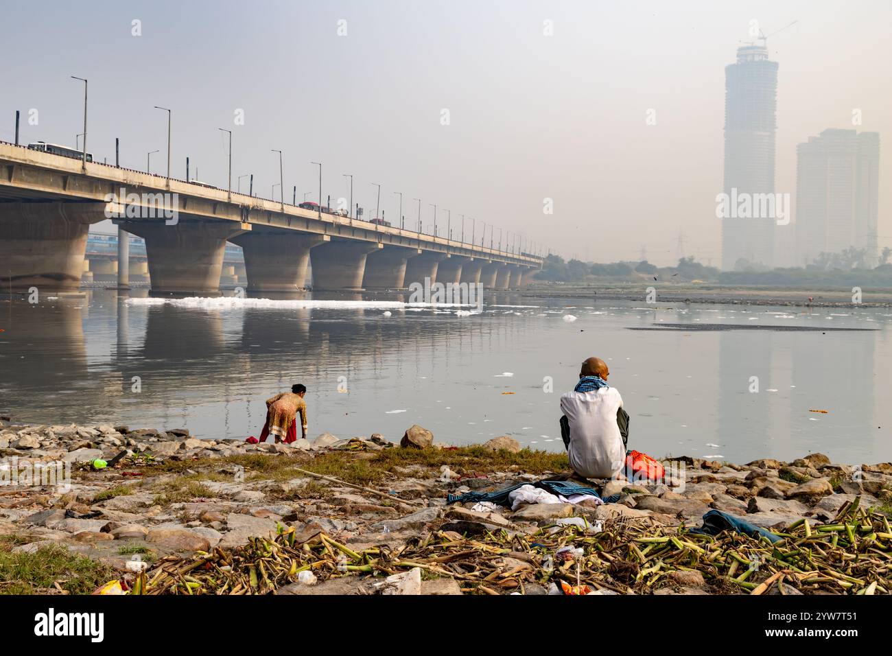 Dévot exécutant des rituels sacrés à la rive de la rivière polluée avec de la mousse toxique à l'image brumeuse du matin est prise à yamuna River okhla barrage delhi inde. Banque D'Images