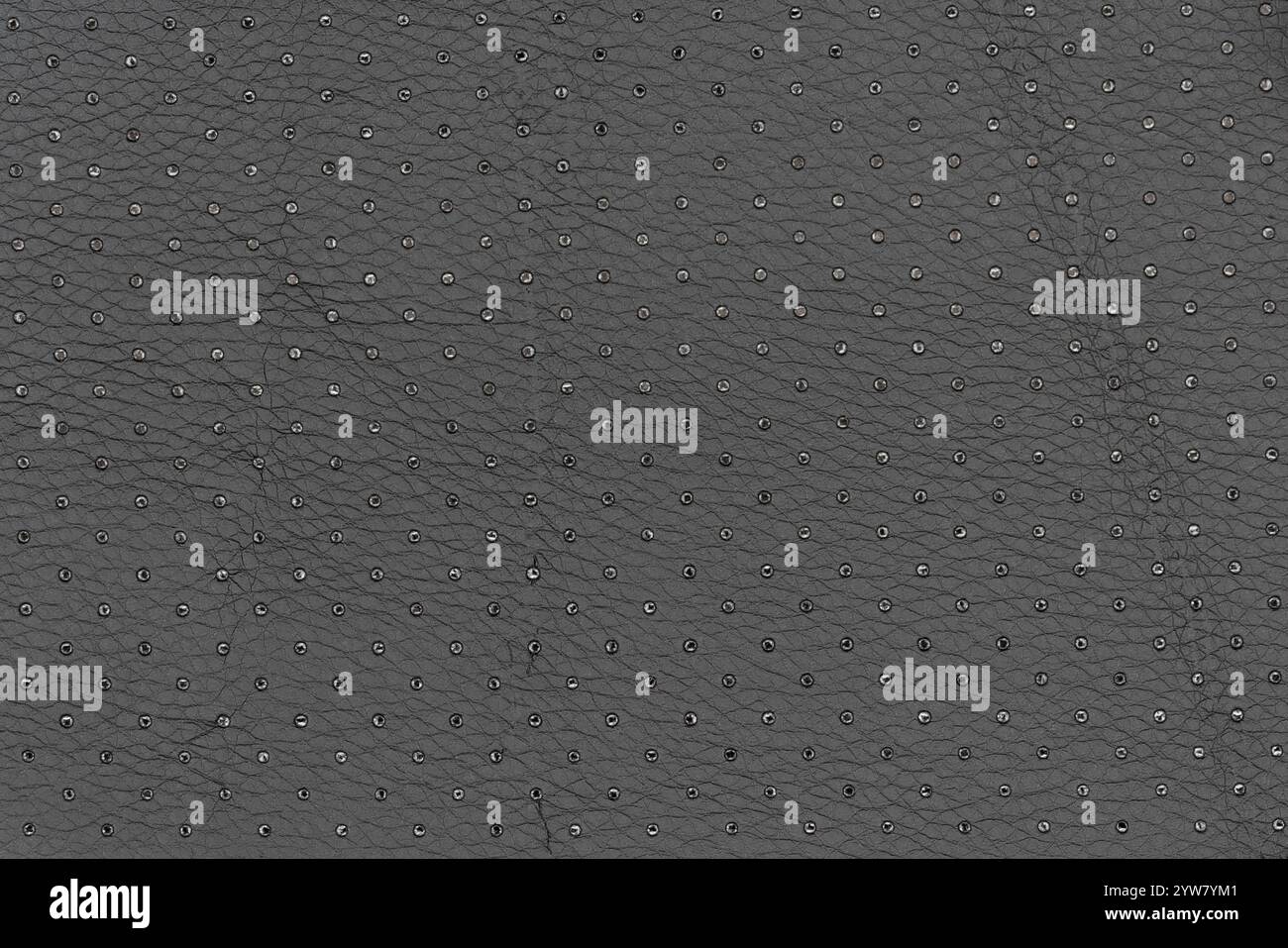 Cuir artificiel abstrait en noir avec petits motifs de points et de trous. Vue sur la table de la surface respirante de couleur galet au niveau de l'arrière-plan, s Banque D'Images