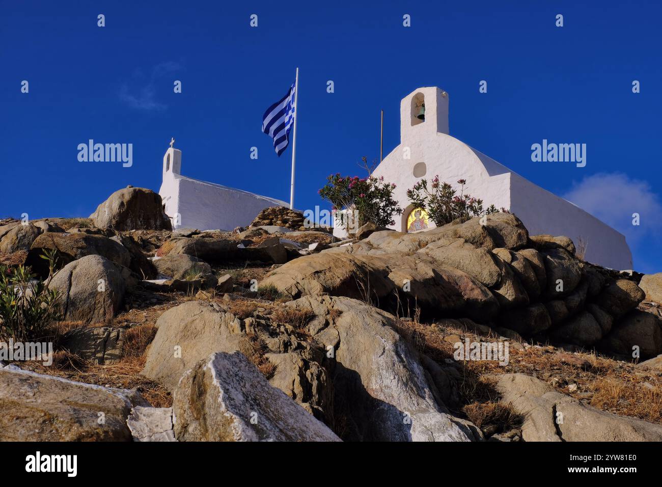 IOS : chapelle Agios Georgios avec mosaïques et chapelle Agios Nikolaos avec drapeau grec sur la colline rocheuse de la ville de iOS (Io) Chora, iOS, île des Cyclades, Grèce Banque D'Images