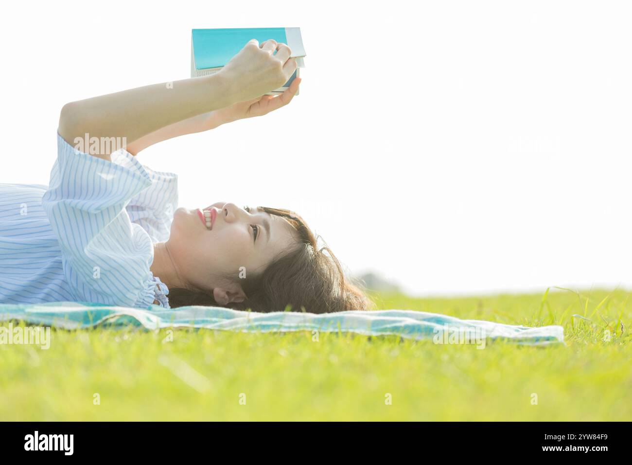 Femme couchée et la lecture d'un livre Banque D'Images