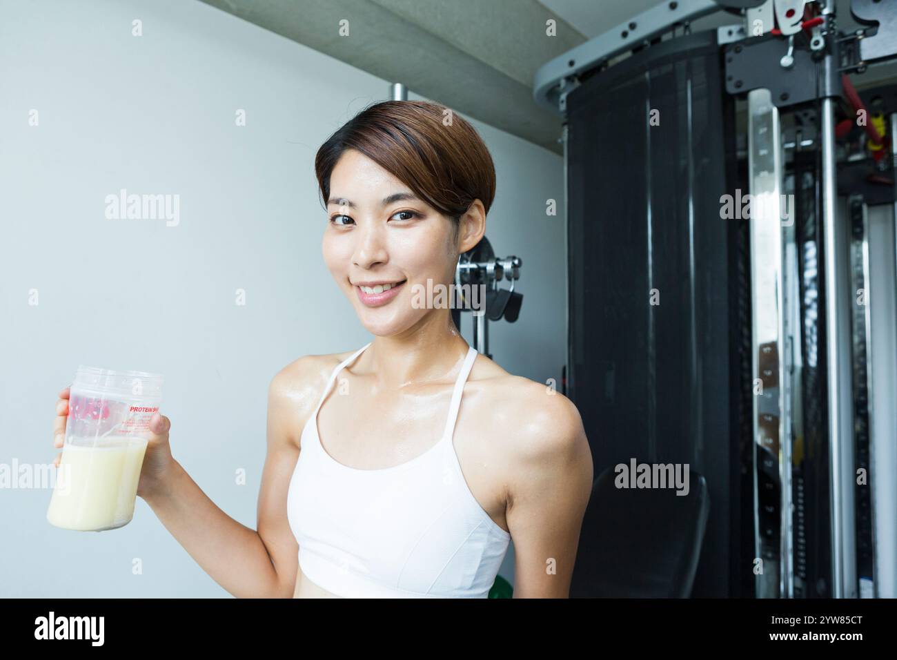 Portrait d'une jeune femme buvant des protéines au gymnase Banque D'Images