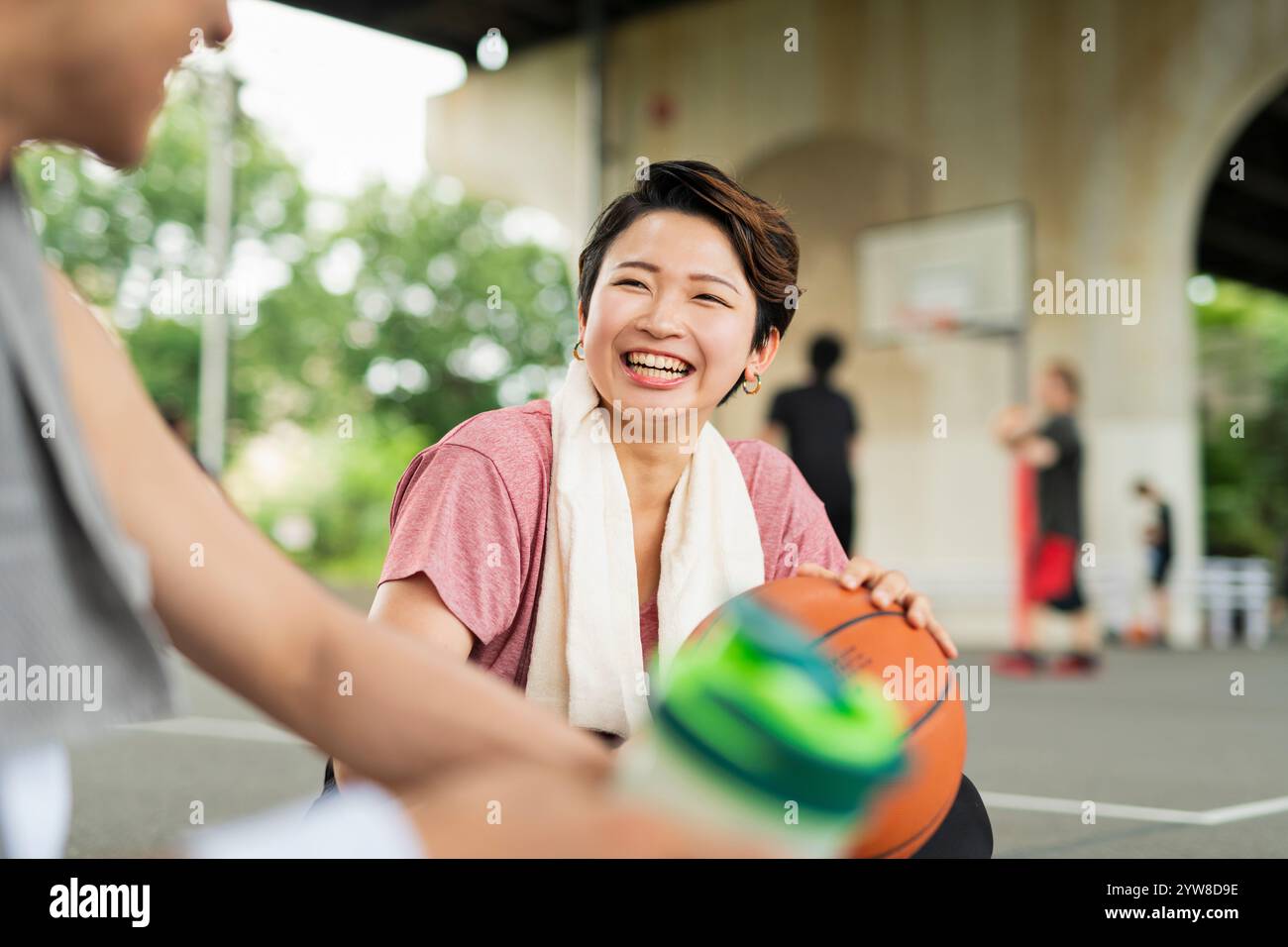 Hommes et femmes prenant une pause pendant la pratique de basket-ball Banque D'Images