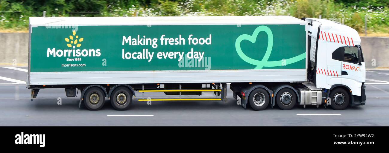 Vue latérale Morrisons supermarché camion semi-remorque graphique publicitaire et nom de marque logo coeur chaîne d'approvisionnement alimentaire M25 autoroute route Angleterre Royaume-Uni Banque D'Images