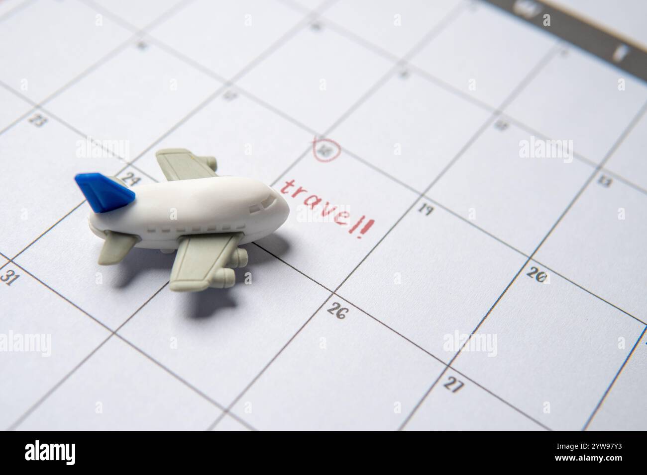 Un jouet d'avion placé près du mot 'voyage' avec la date encerclée sur le calendrier. Planifier un voyage, dans l'attente de voyager concept. Banque D'Images