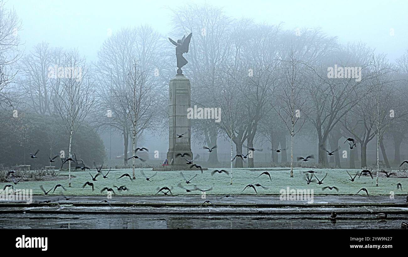 Glasgow, Écosse, Royaume-Uni. 10 décembre 2024. Météo au Royaume-Uni : brouillard glacial et brouillard épais alors que les températures ont chuté pendant la nuit. Victoria Park dans l'extrémité ouest vu étang gelé et faible visibilité toute la journée Spirit of Victory War Memorial statue dans le parc..ce monument est un mémorial aux hommes de Partick et Whiteinch qui sont tombés dans les deux guerres mondiales, crédit Gerard Ferry / Alamy Live News Banque D'Images