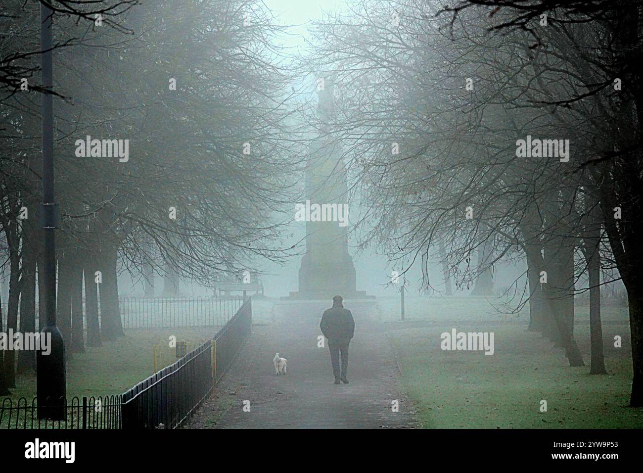 Glasgow, Écosse, Royaume-Uni. 10 décembre 2024. Météo au Royaume-Uni : brouillard glacial et brouillard épais alors que les températures ont chuté pendant la nuit. Victoria Park dans l'extrémité ouest vu étang gelé et faible visibilité toute la journée Spirit of Victory War Memorial statue dans le parc..ce monument est un mémorial aux hommes de Partick et Whiteinch qui sont tombés dans les deux guerres mondiales, crédit Gerard Ferry / Alamy Live News Banque D'Images