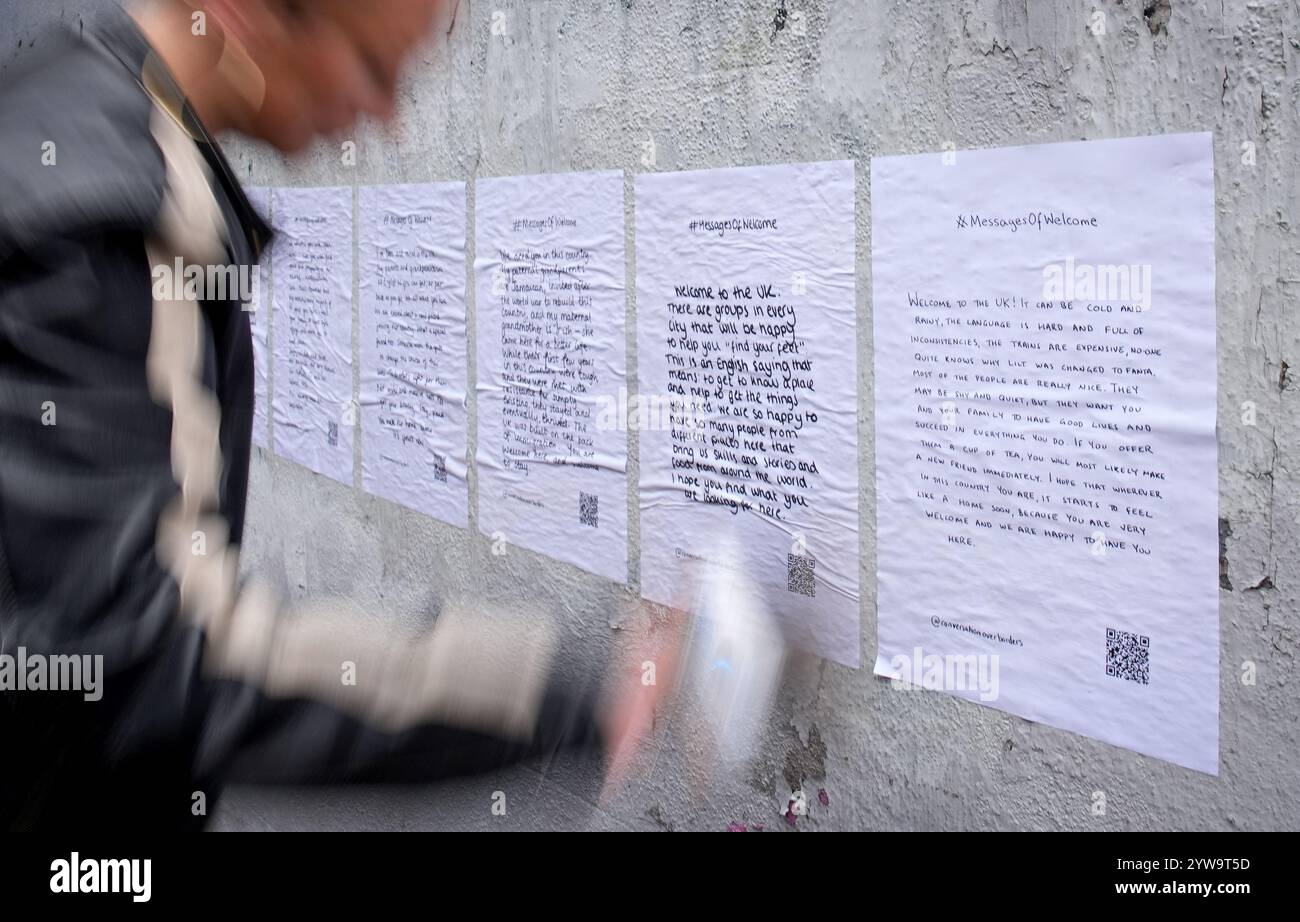 Colette Batten-Turner, PDG de conversation Over Borders, place des affiches avec le message de Noël « Un message de bienvenue » dans la ville de Brighton, dans l'est du Sussex, dans le cadre d'une campagne nationale de l'organisation caritative de réfugiés conversation Over Borders. Des centaines d'affiches présentant des messages manuscrits de compassion envers les demandeurs d'asile sont affichées dans tout le pays à l'approche de Noël dans le cadre d'une campagne nationale visant à créer un «environnement accueillant pour tous» au lendemain des émeutes d'été. Date de la photo : mardi 10 décembre 2024. Banque D'Images
