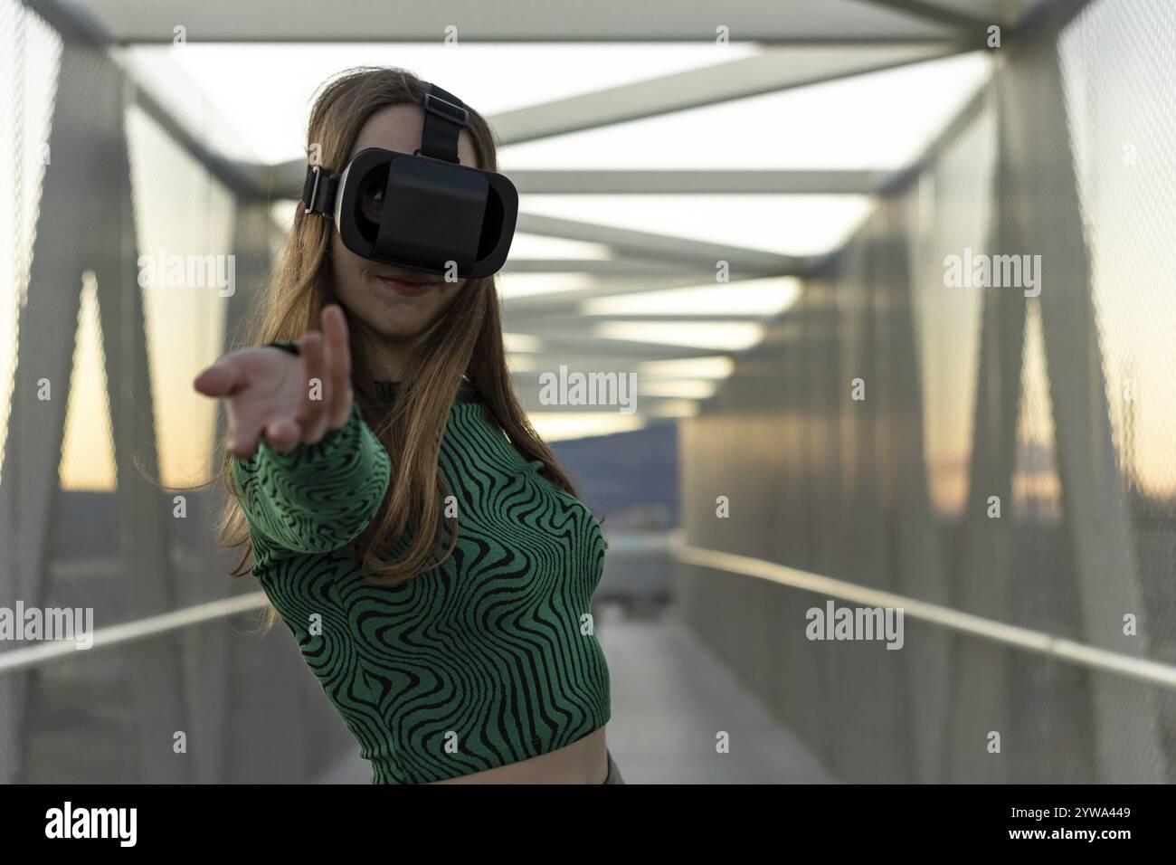 Jeune femme hispanique portant des lunettes de réalité virtuelle, touchez quelque chose comme cliquer sur le bouton, pointant vers l'extérieur sur l'écran virtuel flottant. Péop Banque D'Images