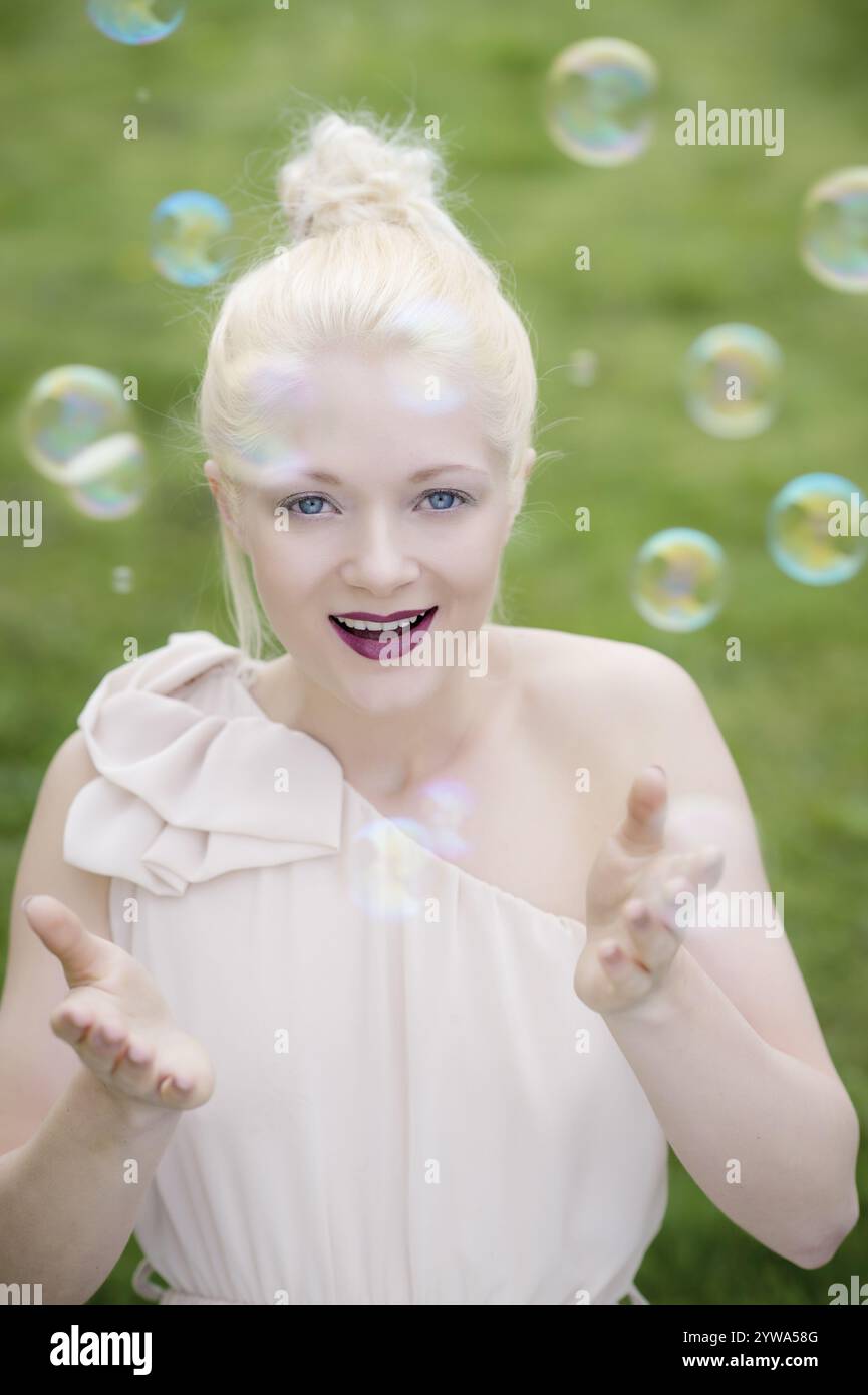 Jeune femme blonde avec des bulles de savon Banque D'Images