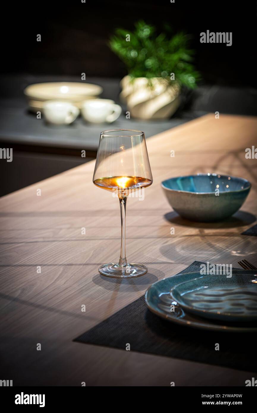 Élégant verre à vin rose qui brille sur un comptoir de cuisine moderne, ajoutant une touche de sophistication à la table à manger Banque D'Images