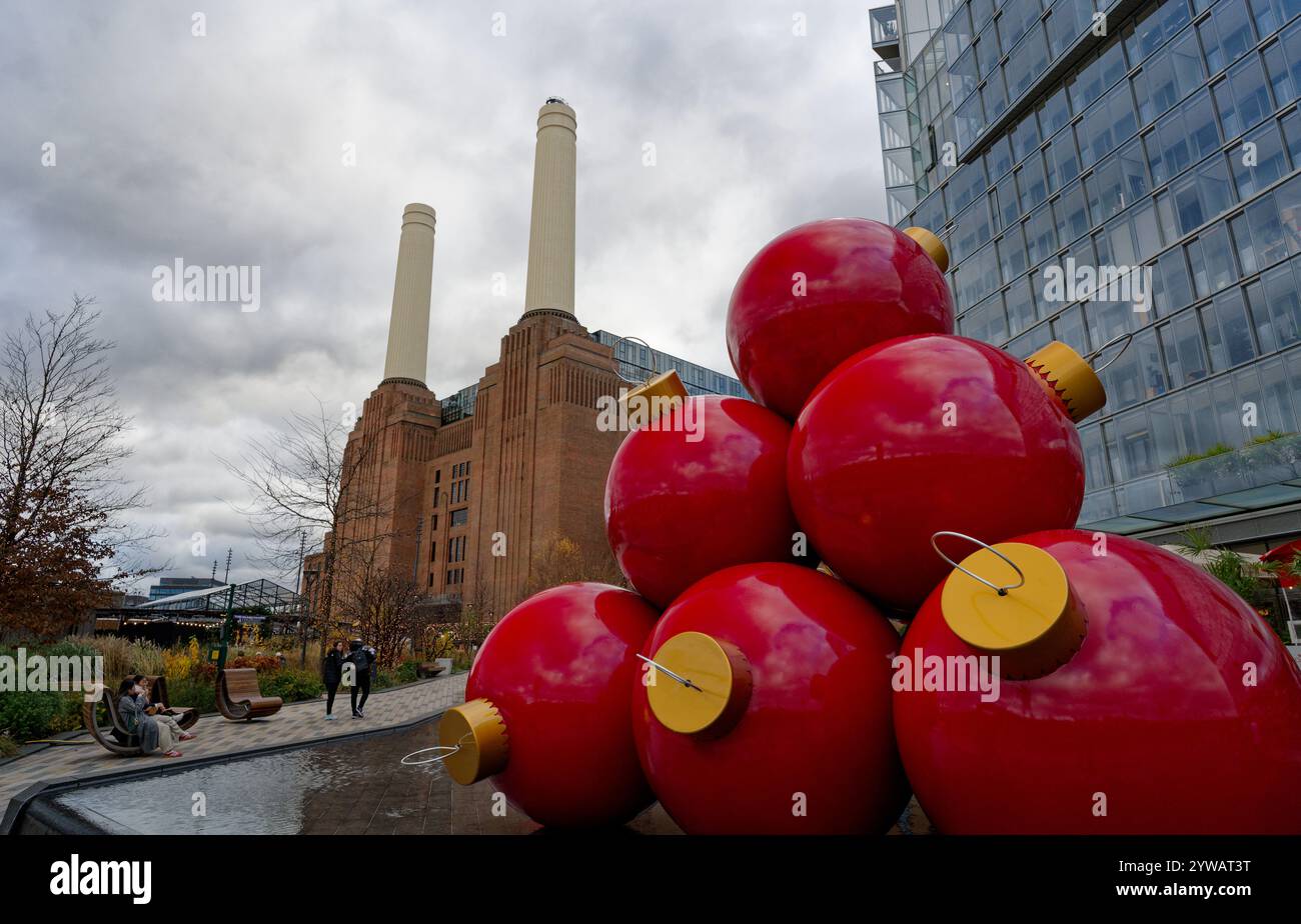 Grands ornements de Noël rouges près de la centrale électrique emblématique de battersea Banque D'Images