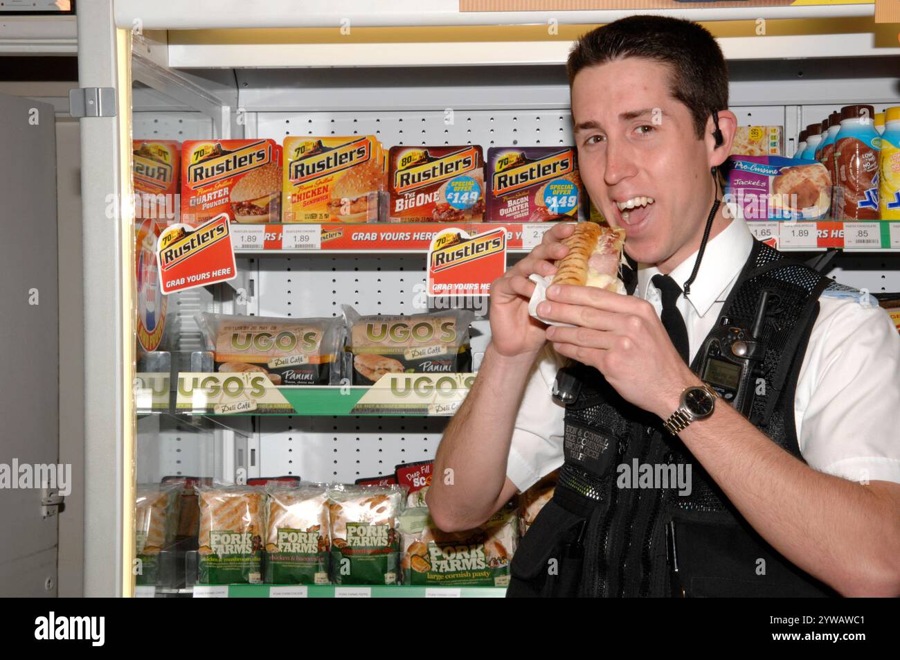 officier de police communautaire mangeant un hamburger Banque D'Images
