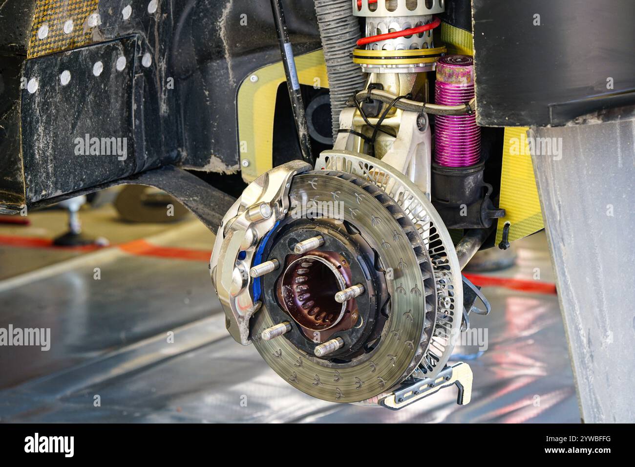 Entretien de voiture de rallye dans le parc de service, suspension haute performance de roue arrière et disque de frein avec étrier Banque D'Images