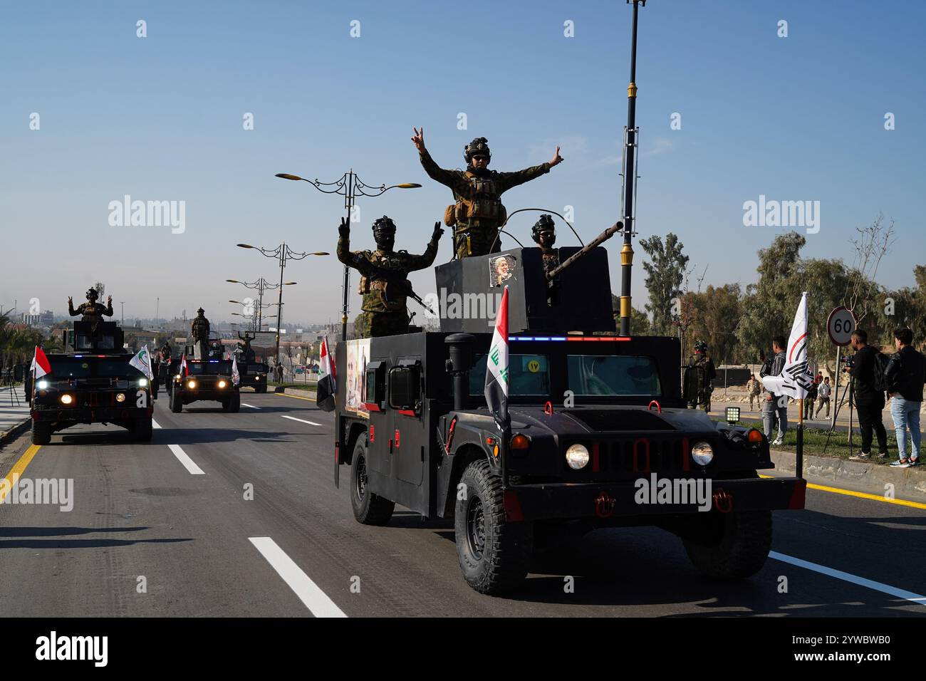 Mossoul, Irak. 10 décembre 2024. Des membres des Forces de mobilisation populaire irakiennes montent à bord d'un véhicule militaire lors d'un défilé militaire célébrant le « jour de la victoire » marquant le septième anniversaire de la défaite des militants de l'État islamique (EIIS) et de la libération des territoires irakiens, à Mossoul, en Irak. L’Irak a déclaré victoire sur l’Etat islamique le 10 décembre 2017, après une bataille de trois ans au cours de laquelle les djihadistes ont saisi de vastes pans du pays, mais des cellules djihadistes lancent encore des attaques sporadiques contre les forces de sécurité, souvent dans les zones rurales. Crédit : SOPA images Limited/Alamy Live News Banque D'Images