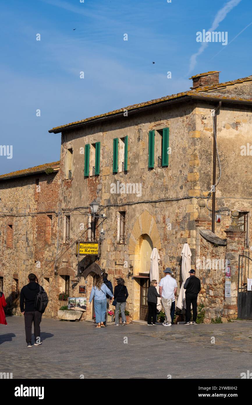 Touristes sur la Piazza Roma dans la ville médiévale fortifiée de Monteriggioni, province de Sienne, Italie. Banque D'Images