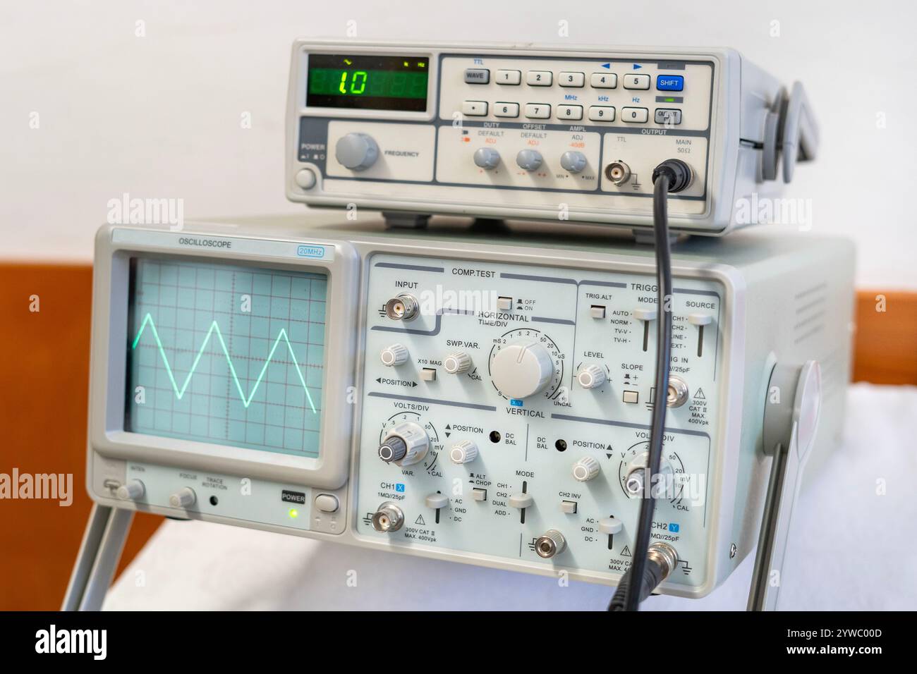 Ondes sinusoïdales vertes sur l'écran d'un oscilloscope à plusieurs boutons Banque D'Images