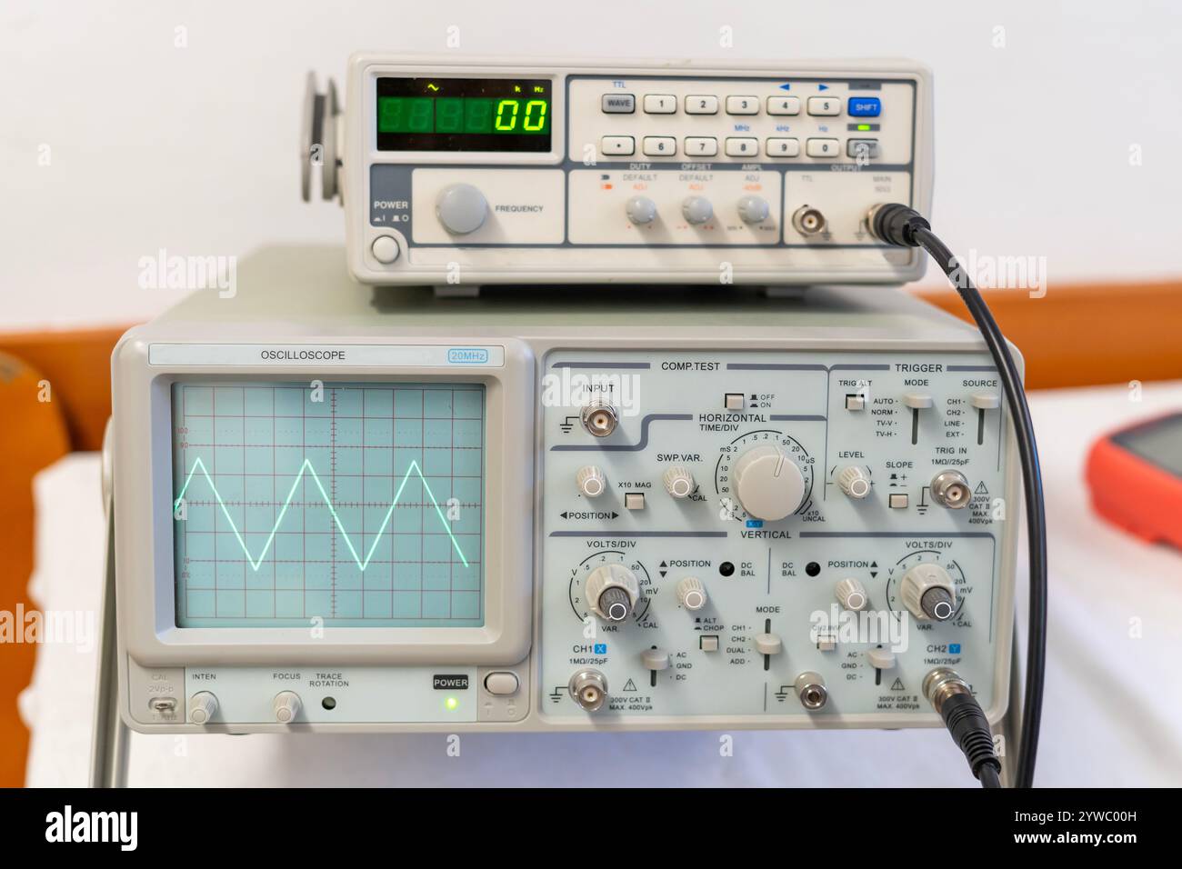 Ondes sinusoïdales vertes sur l'écran d'un oscilloscope à plusieurs boutons Banque D'Images