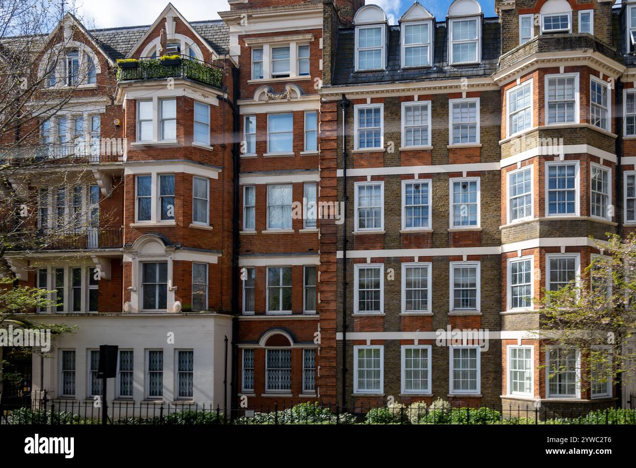 Maisons en briques rouges sur la rue Hans Crescent dans Royal Borough de Kensington et Chelsea, Londres, Royaume-Uni. au printemps Banque D'Images