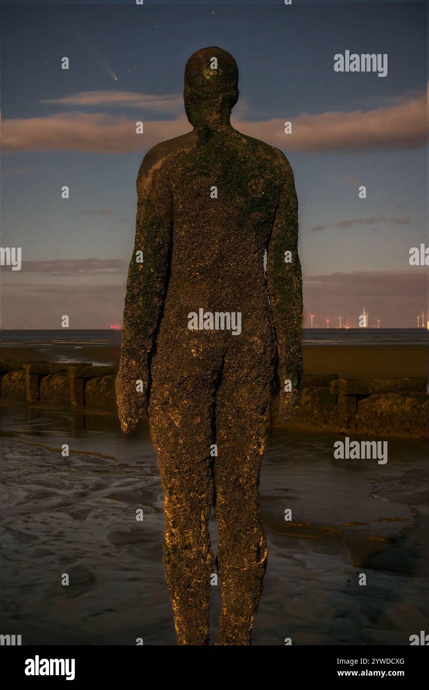 Anthony Gormley's Iron Giant de l'installation artistique 'Another place' regardant vers l'ATLAS Comet 2023/A3 Banque D'Images