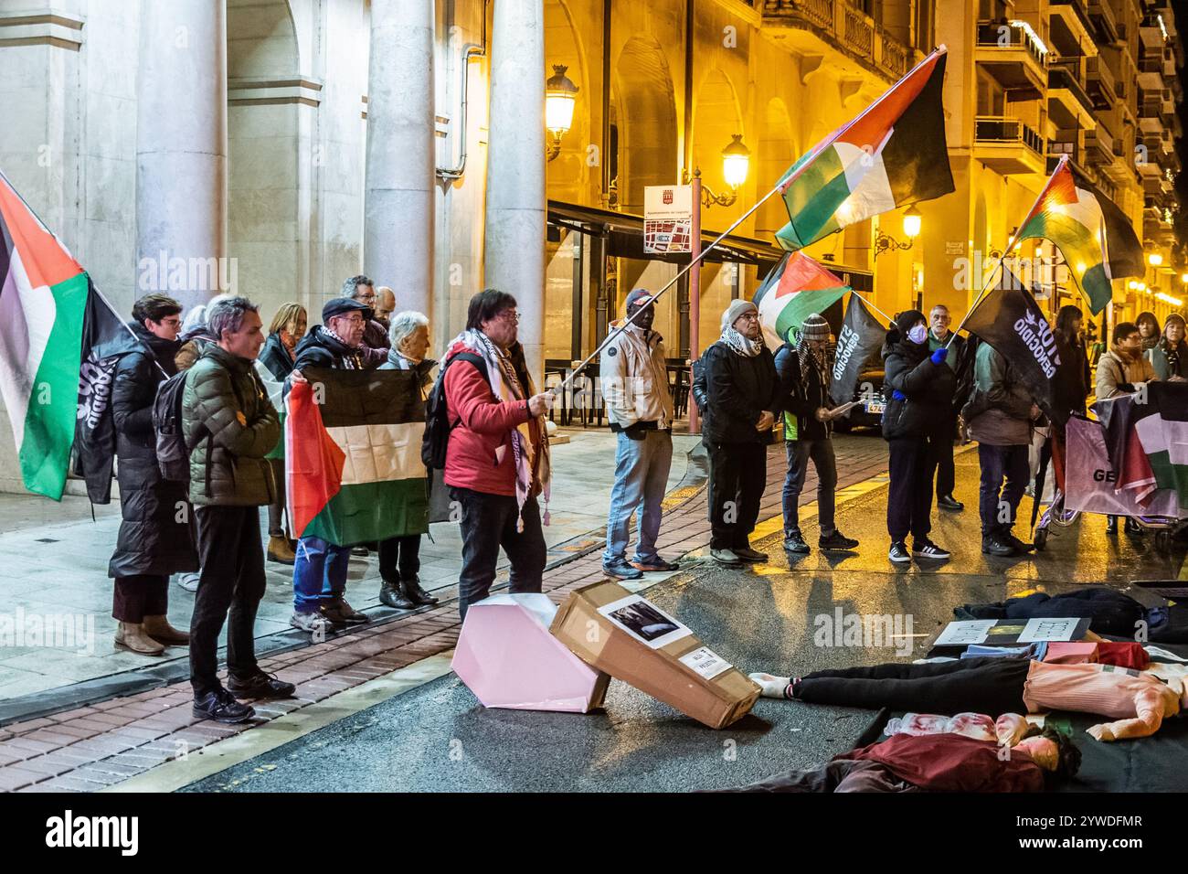 Logrono, la Rioja, Espagne. 11 novembre. 2024. Veillée publique contre l'absence de droits de l'homme en Palestine en raison du génocide perpétré par Israël. Les manifestants tiennent des pancartes et des banderoles exprimant leur opposition au génocide, qui a lieu devant un bâtiment gouvernemental. Il y a des poupées couchées sur le sol, simulant les morts, dans un acte symbolique de protestation ou de commémoration, tandis que les militants pro-palestiniens tiennent des drapeaux et des banderoles. Il y a aussi des objets commémoratifs, tels que des photographies et des fleurs, placés sur le sol. C’est un acte symbolique de protestation ou de commémoration à continuer Banque D'Images