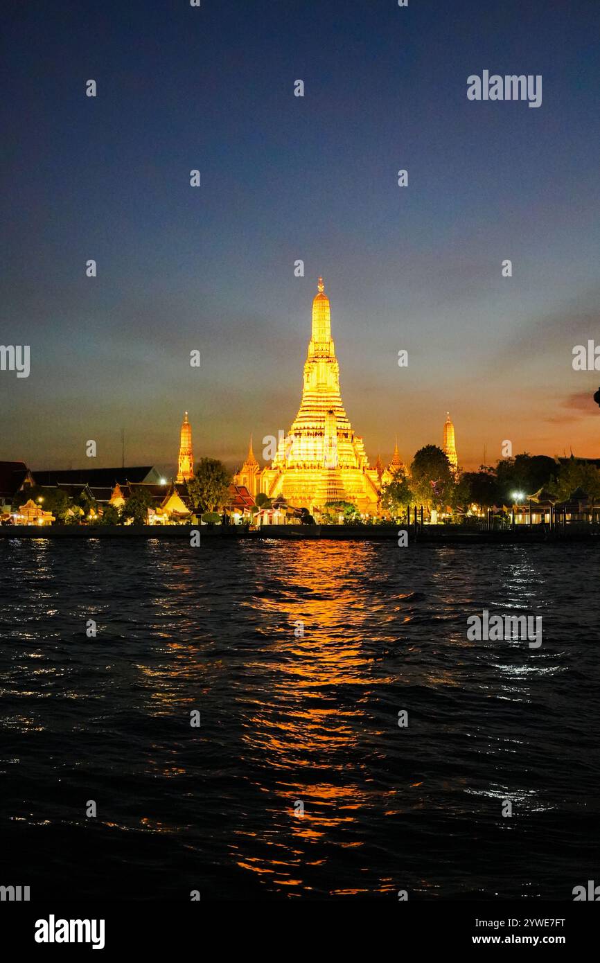 Wat Arun Ratchawararam Ratchawaramahawihan public Landmark à Bangkok au coucher du soleil avec des réflexions sur l'eau de nuit shot. Banque D'Images