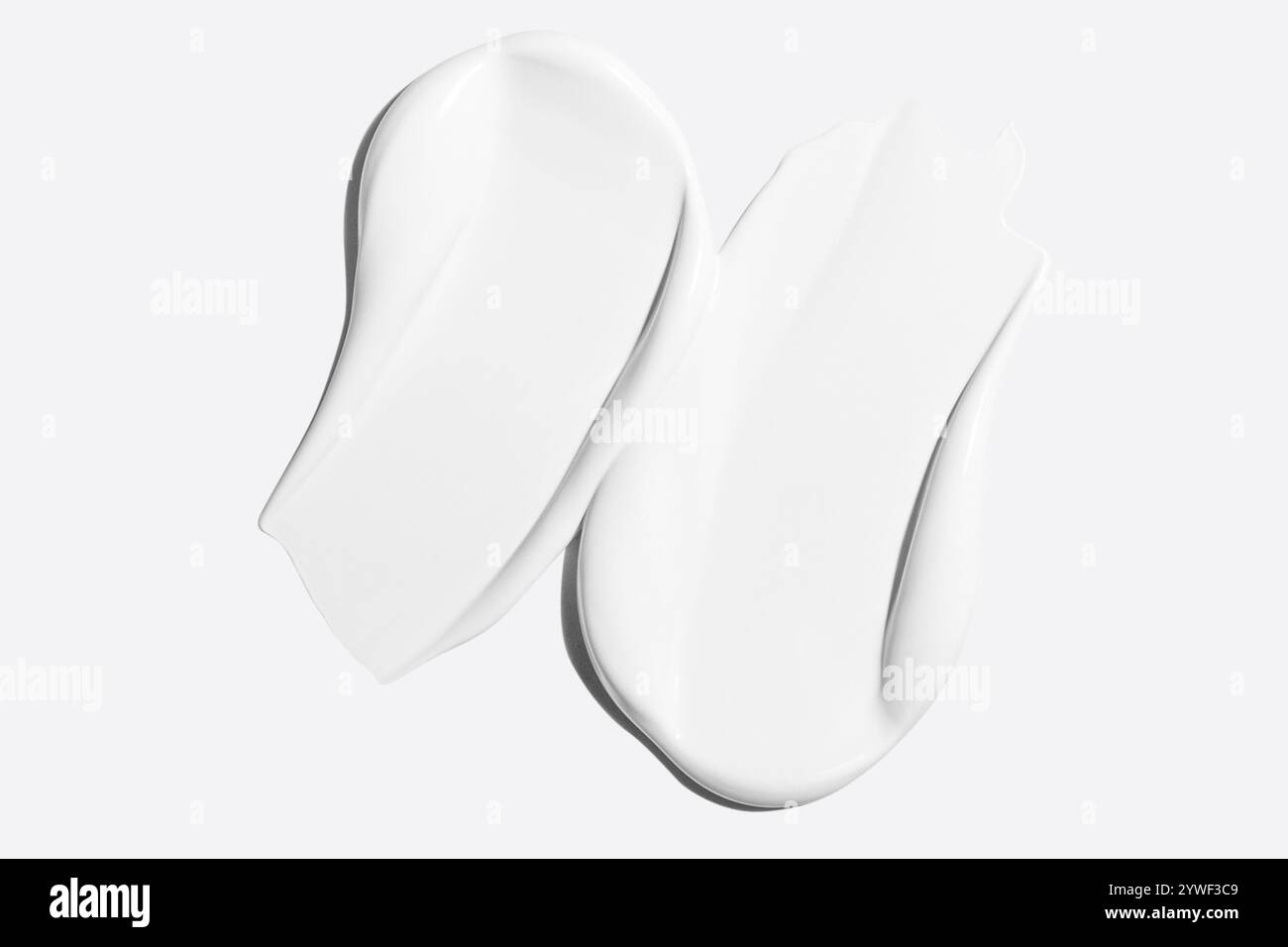 Frottis de crème cosmétique blanche sur un fond clair Banque D'Images