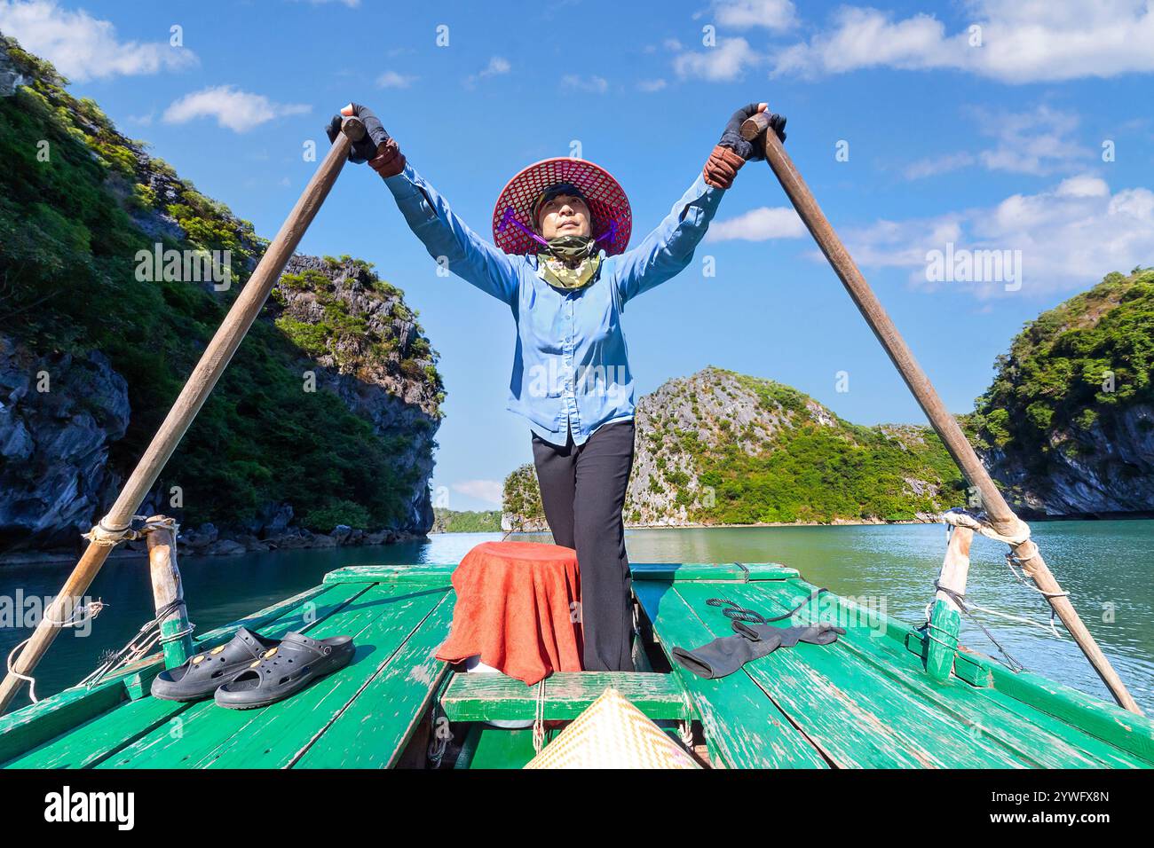 Une femme locale rame dans la baie de Ha long, au Vietnam Banque D'Images