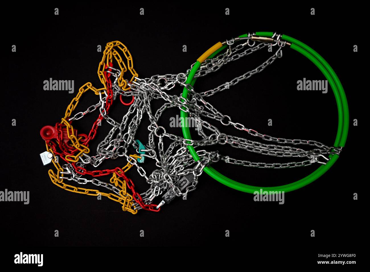 Chaînes à neige neuves avec éléments en plastique rouge, jaune et vert sur fond noir. Banque D'Images