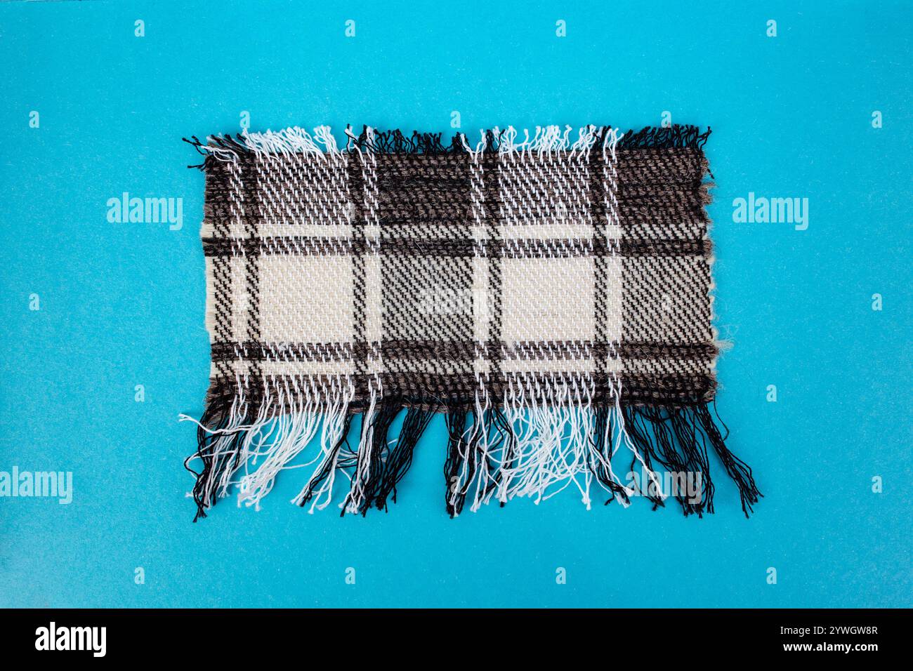 Tissu de laine à carreaux déchiré en forme rectangulaire sur bleu Banque D'Images
