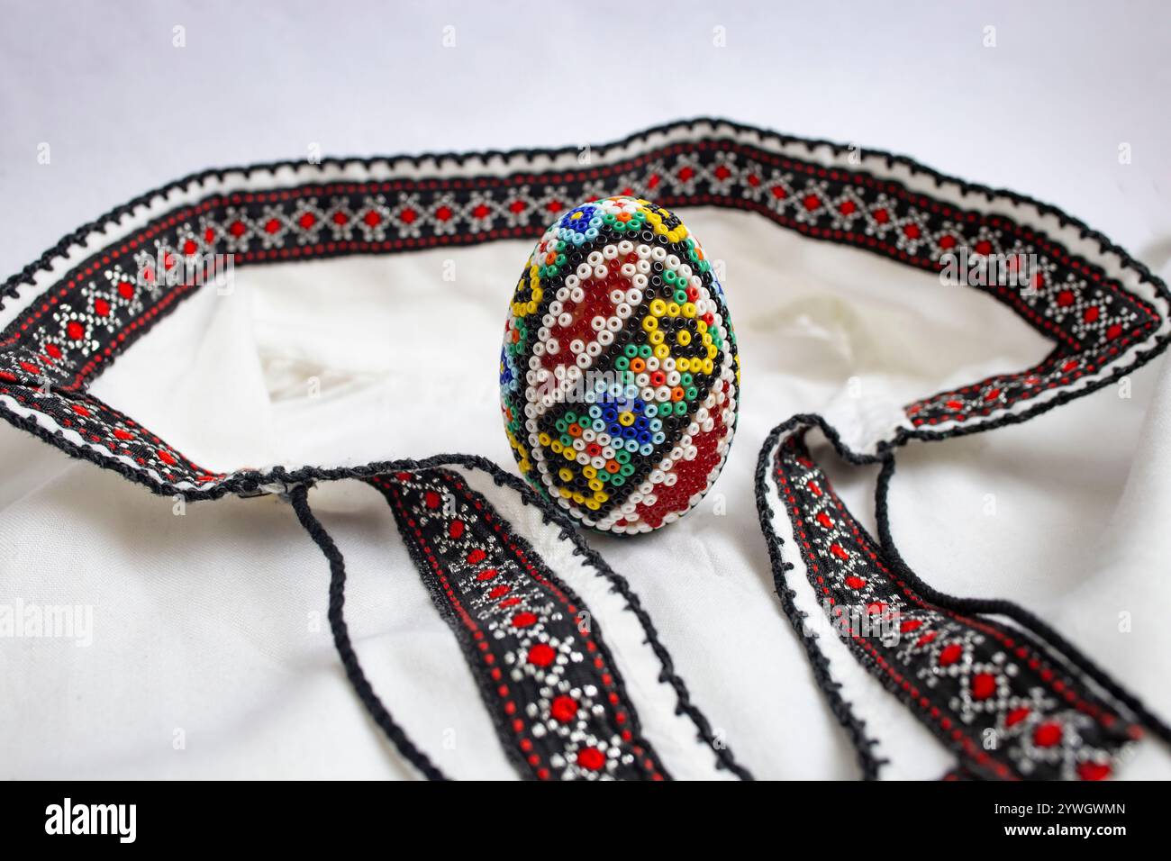 Oeuf de pâques perlé à la main. Perle, sur une blouse ou une chemise ethnique roumaine, détail gros plan doux de mise au point, Banque D'Images