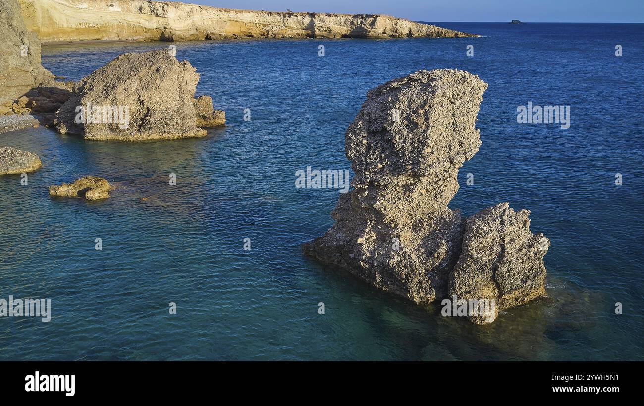 Grand rocher dans l'eau bleue calme, un élément marin impressionnant par temps clair, tir de drone, lumière du soir, Araki Beach, côte sud-ouest, Karpathos, Dodécan Banque D'Images