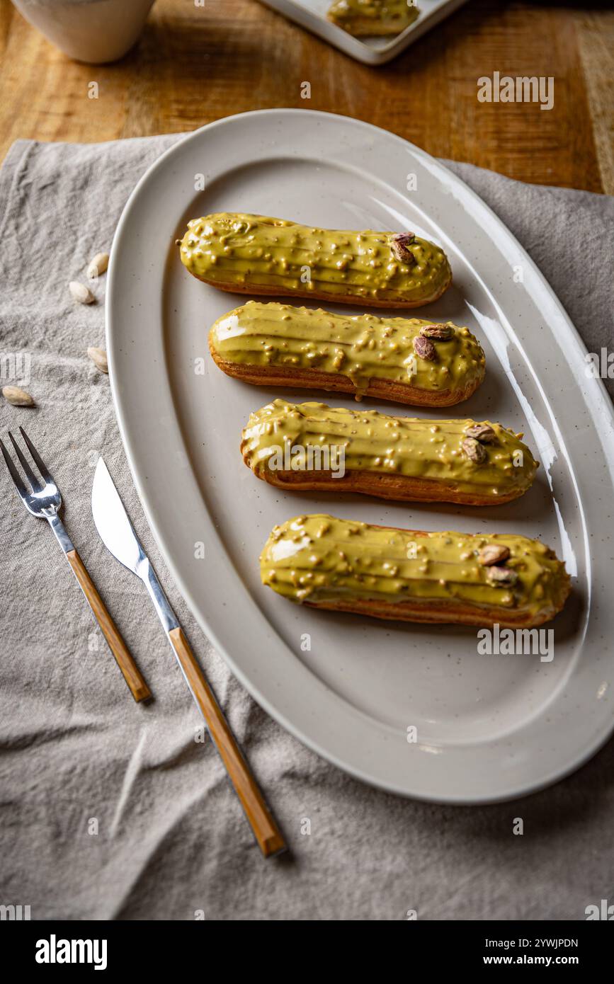 Dessert français traditionnel. Belles eclairs avec glaçage à la pistache Banque D'Images