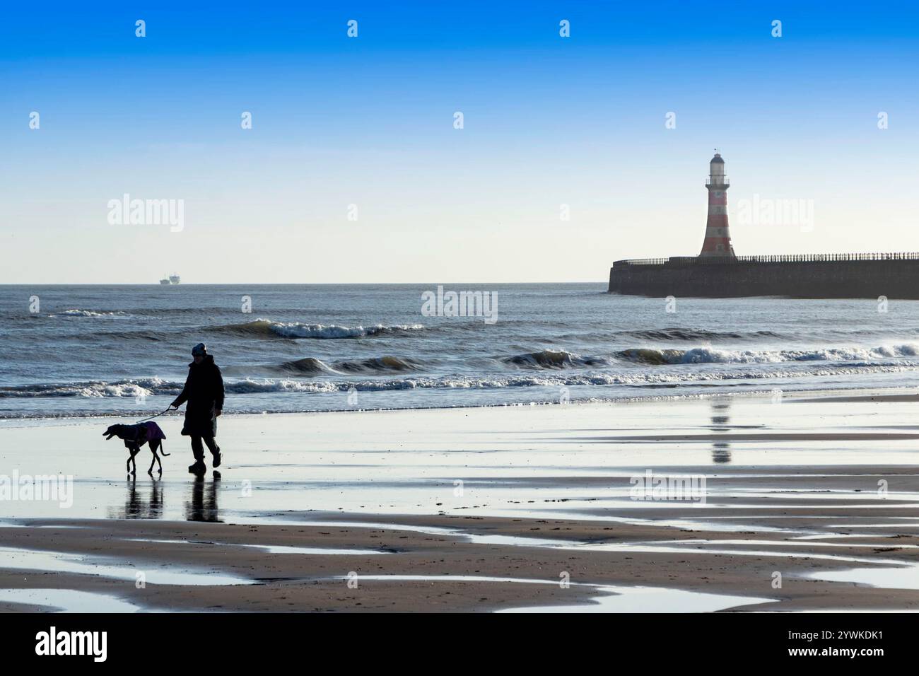 roker jetée et phare et plage avec personne silhouette promenant leur chien sur la plage roker Sunderland tyne & Wear UK Banque D'Images