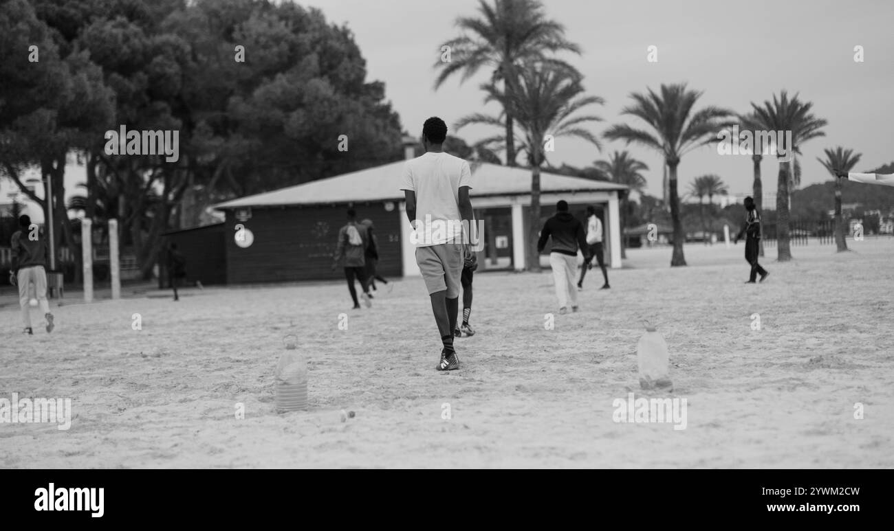 Jeunes Afro-Américains jouant au football sur la plage. Beach football avec des buts de football improvisés fabriqués à partir de bouteilles. Temps libre des jeunes gars Banque D'Images