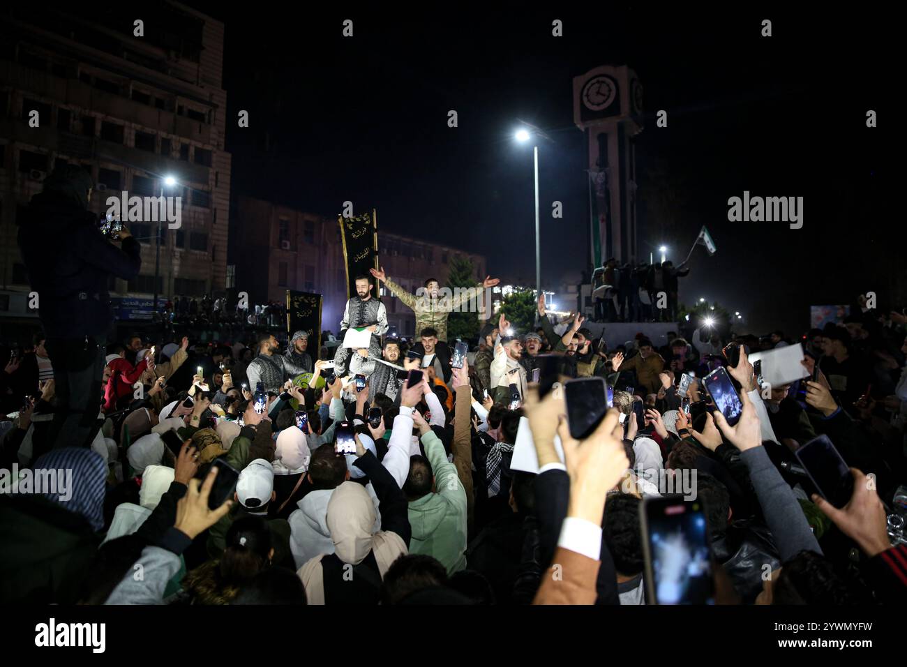 Homs, Syrie. 09 décembre 2024. Un grand nombre de personnes descendent sur la place de l’horloge à Homs pour célébrer la chute du régime d’Al-Assad. Ils ont agité des drapeaux de l'opposition et ont acclamé lorsque les nouvelles leur parvenaient de la chute du gouvernement à Damas alors que Hayat Tahrir al-Sham avançait dans la capitale des forces de l'opposition syrienne Banque D'Images