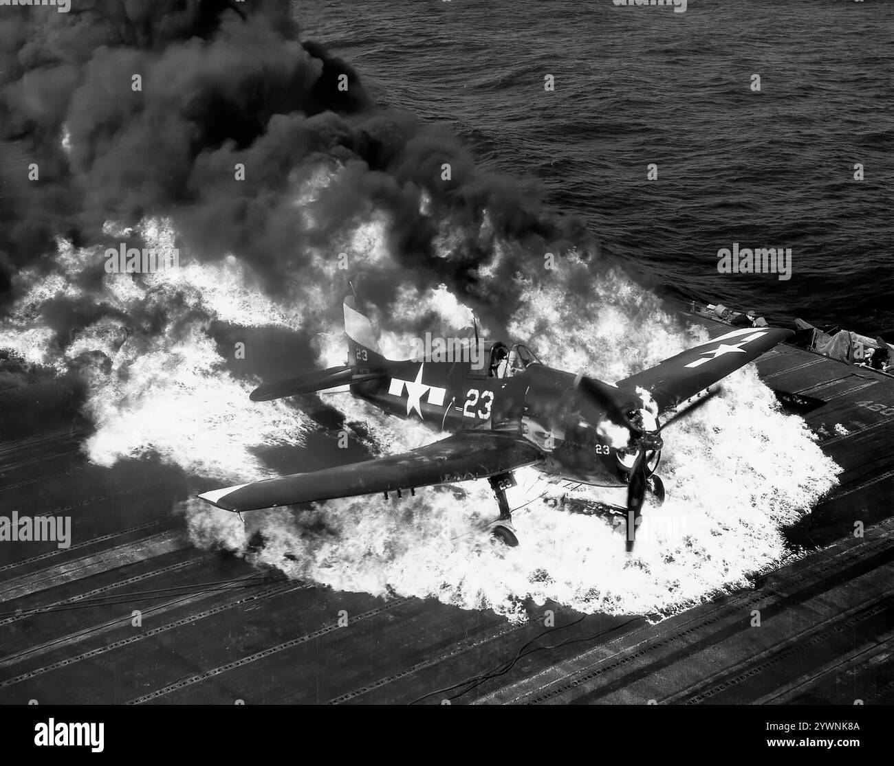 Un Grumman F6F Hellcat écrasé brûlant sur le pont d'envol de dans la mer au large du porte-avions USS Lexington. L'avion de chasse américain de la seconde Guerre mondiale a fait ses débuts au combat en septembre 1943 et s'est par la suite imposé comme un chasseur de porte-avions robuste et bien conçu. Il est devenu le chasseur dominant de la marine des États-Unis dans la seconde moitié de la guerre du Pacifique. Au total, 12 275 avions ont été construits en un peu plus de deux ans et les Hellcats ont été crédités d'avoir détruit un total de 5 223 avions ennemis alors qu'ils étaient en service dans l'US Navy, le US Marine corps et la Royal Navy Fleet Air Arm (FAA). Banque D'Images