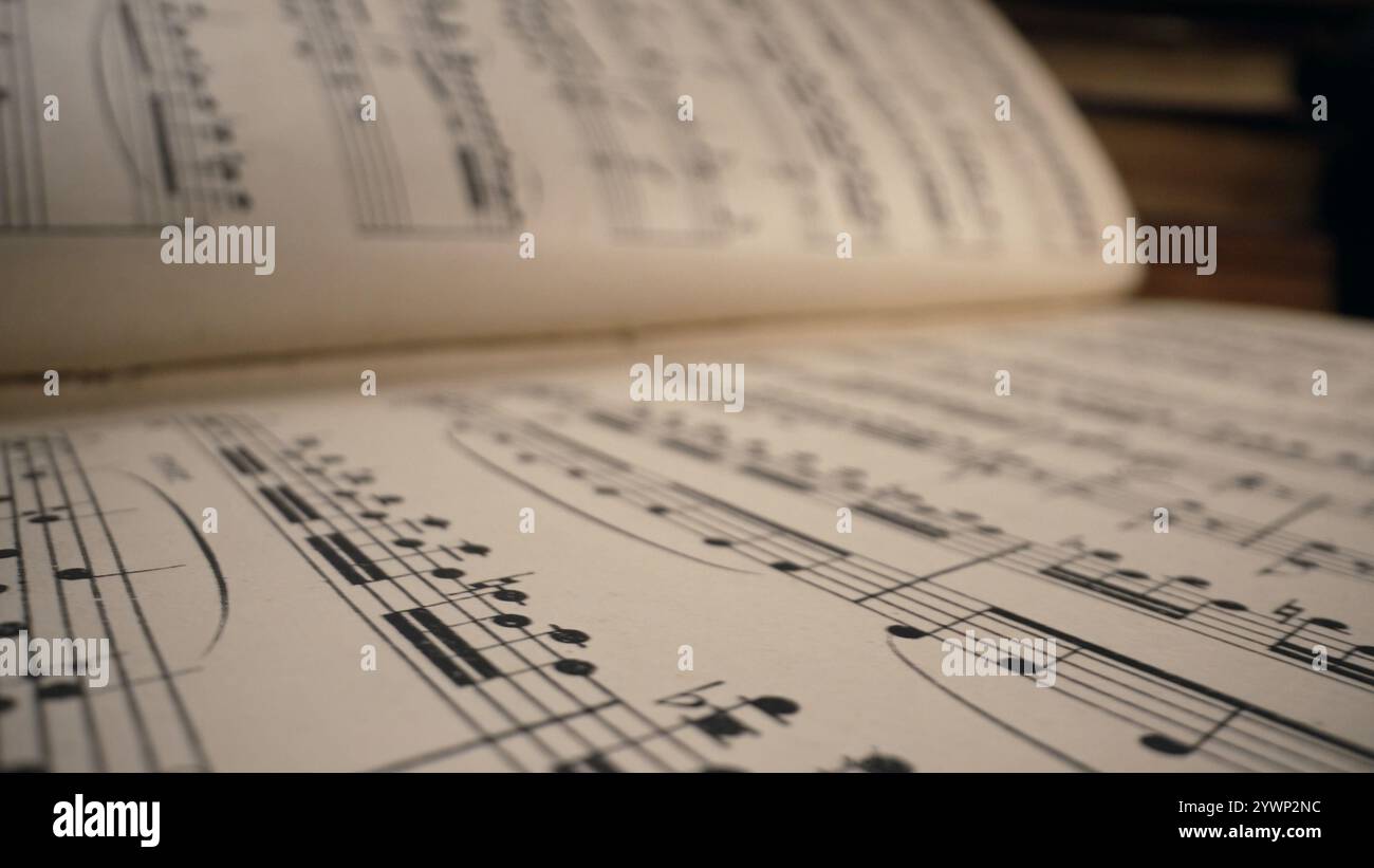 Macro arrière-plan de livre médiéval sauvegardé avec des écrits de notes musicales antiques. Texture de vieille symphonie classique manuscrite, belle mélodie, passe-temps Banque D'Images