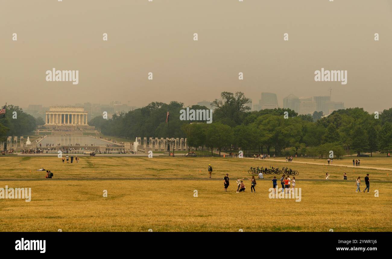 Les touristes et les habitants se promènent dans la brume fumée du National Mall, avec le Lincoln Memorial à peine visible au loin. Banque D'Images