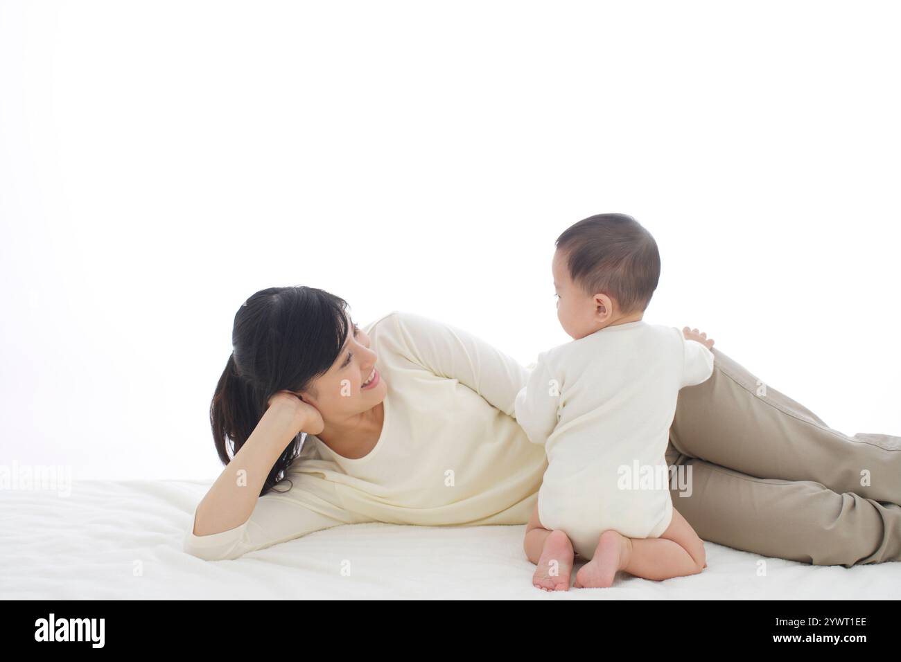 Bébé et mère se relaxant dans le lit Banque D'Images