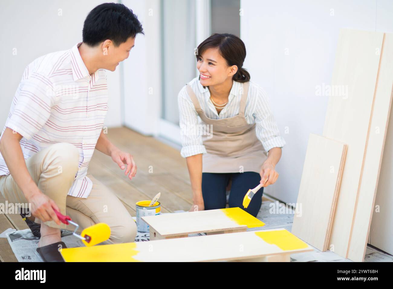 Hommes et femmes peignant sur contreplaqué Banque D'Images
