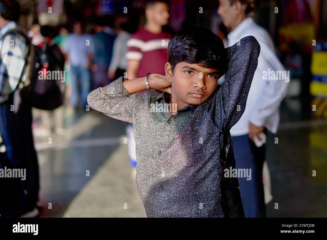 Un garçon sur une plate-forme à Dadar Station (rwy.) À Mumbai, Inde, étire pour frapper une pose relaxante (photo franche, non posée) Banque D'Images