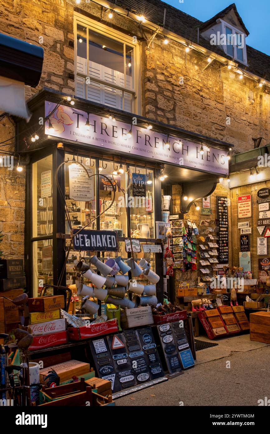 Lumières de Noël sur la boutique de cadeaux des trois poules françaises au crépuscule. Burford, Cotswolds, Oxfordshire, Angleterre Banque D'Images